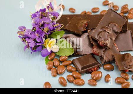 Dark chocolate with raisins, chocolate balls and a cup of coffee on a blue surface Stock Photo