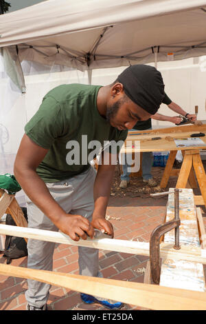 Carpenter using plane on wood plank - USA Stock Photo