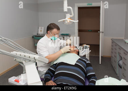 doctor in white medical gown treats teeth patient Stock Photo