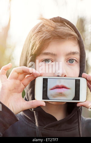 virtual realty, teenage boy holding a smart phone in front of his face Stock Photo