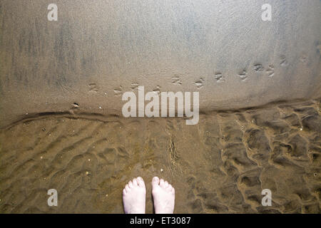 Abstract sand pattern with feet, looking down, seaside natural organic landscape detail. Stock Photo