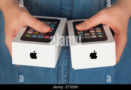 Tambov, Russian Federation - January 12, 2015 Two Apple iPhone boxes in womans hands.  Studio shot. Stock Photo