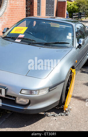 Untaxed car with clamped wheel and a notice attached to the windscreen by the DVLA, Nottinghamshire, England, UK Stock Photo