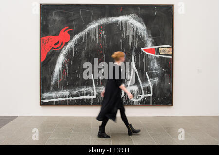 Duesseldorf, Germany. 11th June, 2015. A woman walks past an untitled painting (approx. 1974, acrylic and chalk on canvas) by the Catalan painter Miro (1893-1983) before a press conference in the Kunstsammlung Nordrhein-Westfalen in Duesseldorf, Germany, 11 June 2015. The exhibition 'Miro. Painting as Poetry.' - which includes around 110 pieces from all periods of the artist's work - can be seen from 13 June to 27 September 2015 in K20. Photo: MAJA HITIJ/dpa/Alamy Live News Stock Photo