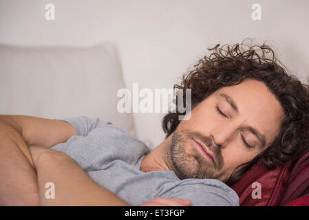 Mid adult man sleeping on couch, Munich, Bavaria, Germany Stock Photo