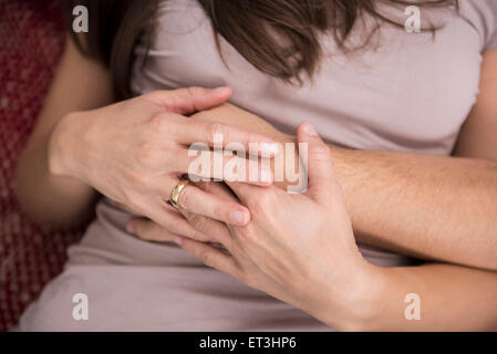 Mid section view of a couple holding hands, Munich, Bavaria, Germany Stock Photo