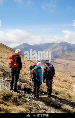 Hikers look at view to Mount Snowdon Horseshoe on path from Moel Siabod to Capel Curig in mountains of Snowdonia Wales UK. Stock Photo