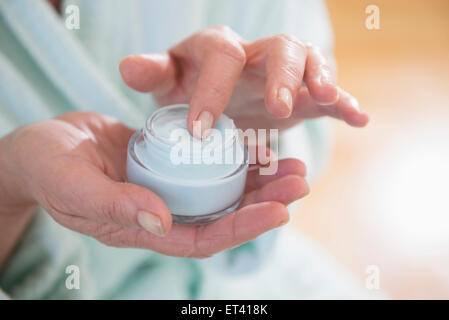 Senior woman applying moisturizer, Munich, Bavaria, Germany Stock Photo