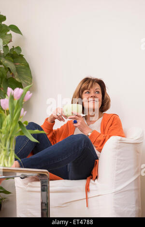 Senior woman dreaming while drinking tea at home, Munich, Bavaria, Germany Stock Photo