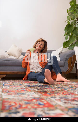 Senior woman dreaming while drinking tea at home, Munich, Bavaria, Germany Stock Photo