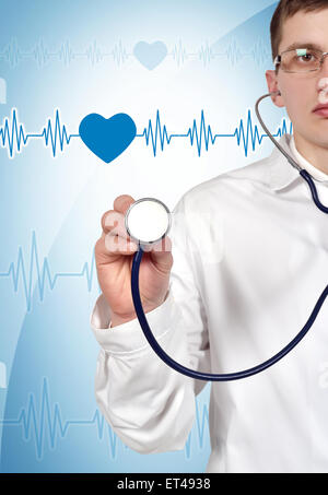 Young doctor holding stethoscope on blue background Stock Photo