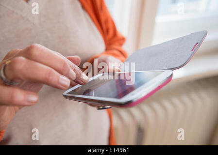 Mid section view of an old woman touching smart phone, Munich, Bavaria, Germany Stock Photo