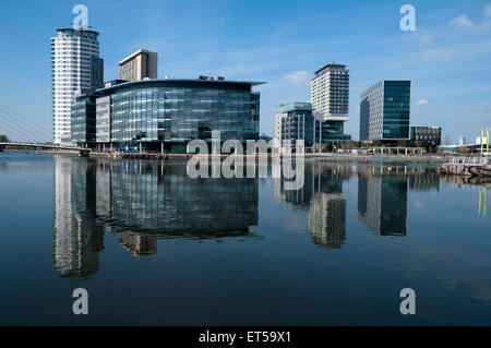 The MediaCityUK complex reflected in the Manchester Ship Canal, Salford Quays, Manchester, England, UK Stock Photo