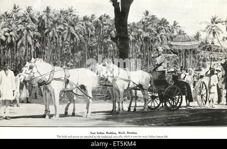 Old vintage 1900s Indian Wedding bride and groom in horse cart under traditional umbrella , Worli , Bombay , Mumbai , Maharashtra , India , Asia Stock Photo