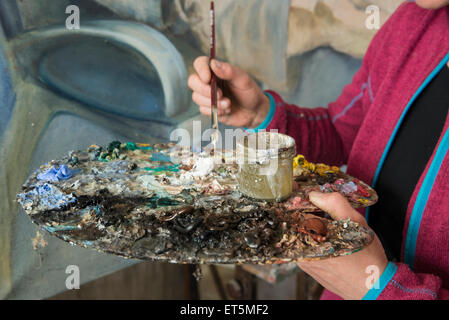 Woman mixing colors while painting, Bavaria, Germany Stock Photo