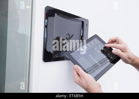 Man operating control panel on wall mounted, Munich, Bavaria, Germany Stock Photo