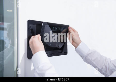Man operating control panel on wall mounted, Munich, Bavaria, Germany Stock Photo