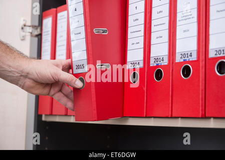 Man taking confidential file from filing cabinet, Munich, Bavaria, Germany Stock Photo