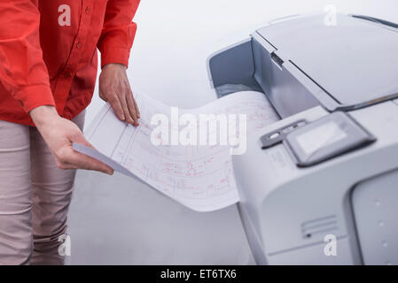 Woman using photocopier in office, Munich, Bavaria, Germany Stock Photo