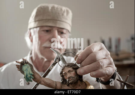 Senior sculptor works on a Jesus Christ statue at a workshop, Bavaria, Germany Stock Photo