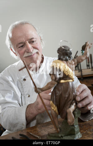 Senior sculptor works on a Jesus Christ statue at a workshop, Bavaria, Germany Stock Photo