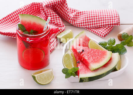 Fresh watermelon with juice. Healthy organic watermelon snack in jar and fresh watermelon slice in heart shape bowl.. Stock Photo