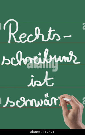 Close up of person's hand writing on chalkboard, Bavaria, Germany Stock Photo
