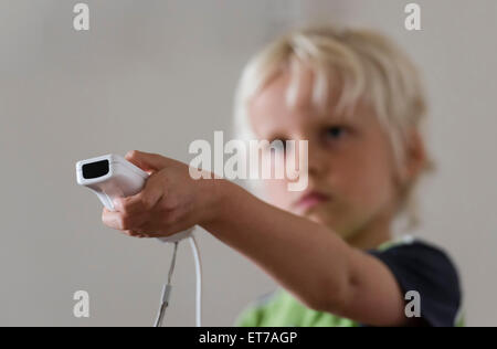 7 year old boy at home playing Nintendo Wii computer game with Nintendo game controller in his hand. Stock Photo