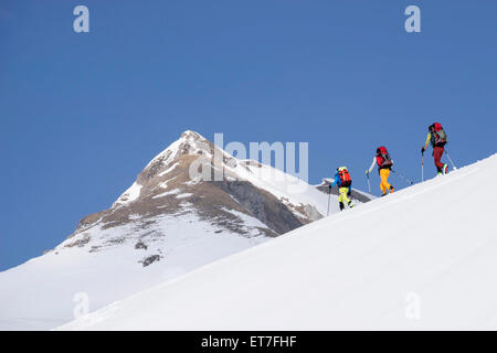 Ski mountaineers climbing on snowy peak, Tyrol, Austria Stock Photo