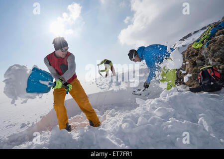 Men shovelling snow for bivouac camp, Tyrol, Austria Stock Photo