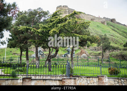 Monument in front of hill with medieval citadel called Gori Fortress in Gori town, Goergia Stock Photo