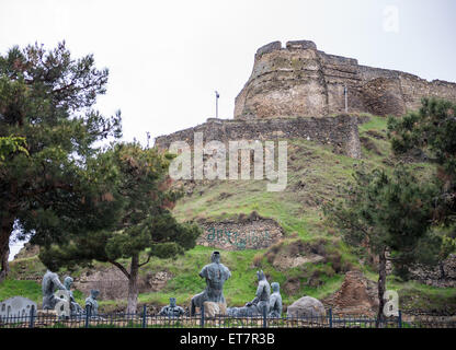 Monument in front of hill with medieval citadel called Gori Fortress in Gori town, Goergia Stock Photo