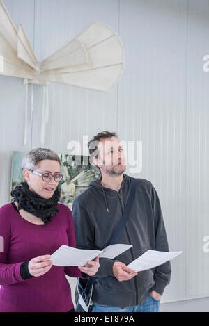 Visitors looking at brochures in an art gallery, Bavaria, Germany Stock Photo