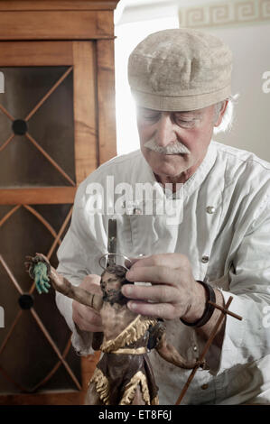 Senior sculptor works on a Jesus Christ statue at a workshop, Bavaria, Germany Stock Photo