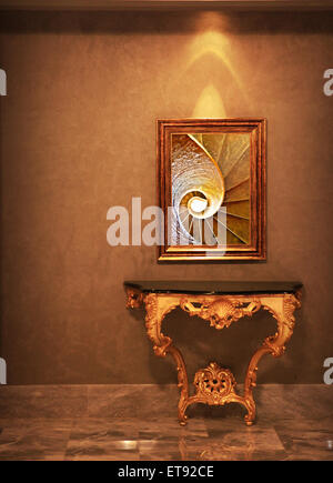 display luxury frame holding a painting or photo of spiral pattern (golden ratio) over luxury table, all tuned to golden color. Stock Photo