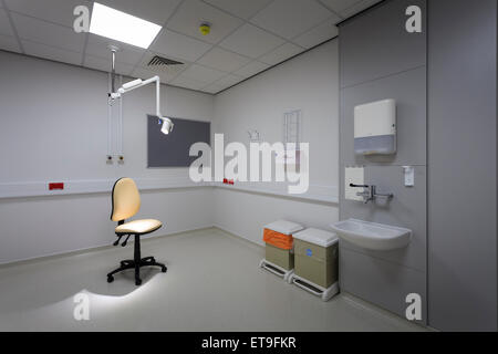 single unoccupied chair in examination room with examination light without people Stock Photo