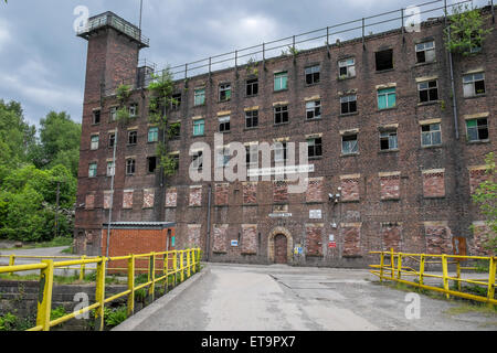 A Disused factory which has bricked up windows and door to the second floor Stock Photo