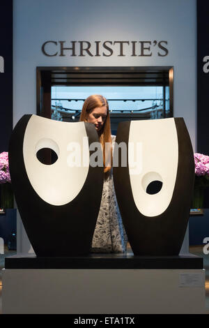 A Christie's employee poses with Dame Barbara Hepworth's sculpture 'Two Forms with White (Greek), estimate: GBP 1.3-1.8 million. Preview of the highlights of the Christie's Modern British and Irish Art Evening Sale on 25 June 2015 in London. Stock Photo