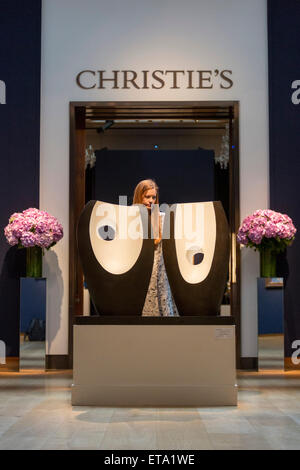 A Christie's employee poses with Dame Barbara Hepworth's sculpture 'Two Forms with White (Greek), estimate: GBP 1.3-1.8 million. Preview of the highlights of the Christie's Modern British and Irish Art Evening Sale on 25 June 2015 in London. Stock Photo