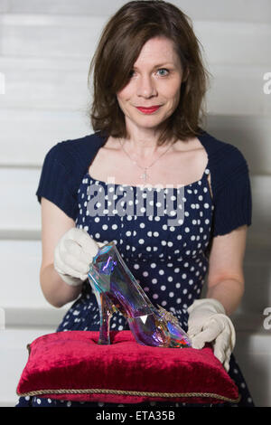 Curator Helen Persson holds Disney's Cinderella slipper ahead of the new V&A summer fashion exhibition 'Shoes: Pleasure and Pain' which focuses on the transformative power of shoes. The slipper was created by Swarovski under the direction of Academy Award-winning costume designer Sandy Powell. It was hewn from solid Swarovski crystal and features 221 facets in a light-reflecting Crystal Blue Aurora Borealis coating. The exhibition Shoes: Pleasure and Pain opens to the public on 13 June 2015 and runs to 31 January 2016. Stock Photo