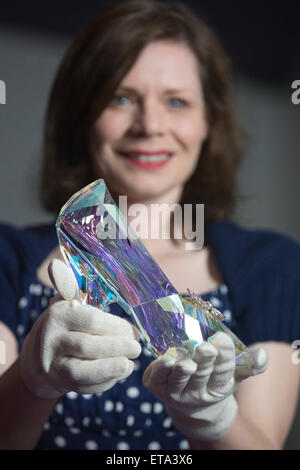 Curator Helen Persson holds Disney's Cinderella slipper ahead of the new V&A summer fashion exhibition 'Shoes: Pleasure and Pain' which focuses on the transformative power of shoes. The slipper was created by Swarovski under the direction of Academy Award-winning costume designer Sandy Powell. It was hewn from solid Swarovski crystal and features 221 facets in a light-reflecting Crystal Blue Aurora Borealis coating. The exhibition Shoes: Pleasure and Pain opens to the public on 13 June 2015 and runs to 31 January 2016. Stock Photo