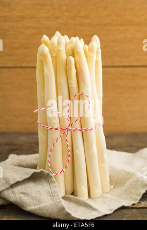 Bunch of fresh white asparagus on wooden table with linen cloth Stock Photo