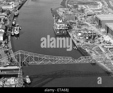 Aerial view of the biggest ever oil rig module to be made in Britain, as it waits to be towed under the Tees Transporter Bridge, on its way from Cleveland Offshore, Port Clarence to the Beatrice oil field off Scotland, 27th September 1983. Stock Photo