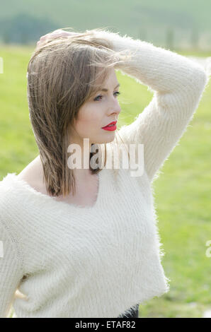 Beautiful young woman hand touching hair looking away Stock Photo