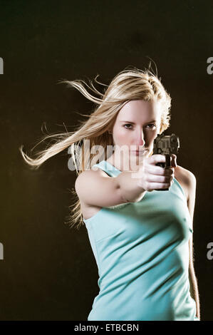 Dangerous young woman holding a gun Stock Photo