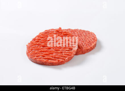 two raw hamburger patties on white background Stock Photo