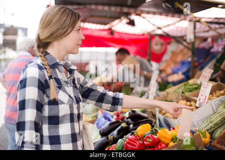 young woman showing a market trader what she wants. Stock Photo