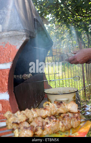 human hands roasting appetizing  barbecue from pork on the fire Stock Photo