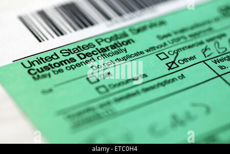 shipping mail package box with the U.S POST OFFICE Sticker label in main Focus showing the Customs Declaration form filled. Stock Photo