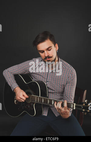handsome guy with beard holding acoustic guitar Stock Photo